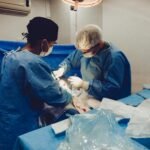 Surgeons focusing on a procedure in an equipped operating room, showcasing teamwork and precision.